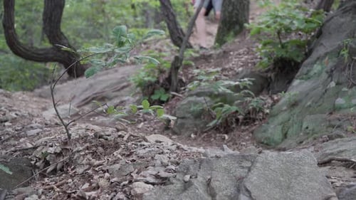Blurred legs of Male Hiker walking down A Rocky Mountain With Narrow Path - Medium Shot, hiking con