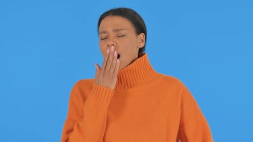 Gähnende lässige Afrikanerin auf blauem Hintergrund, Portrait