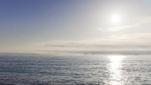 Mar Negro y playa cercanos contra un cielo con nubes y un sol al amanecer