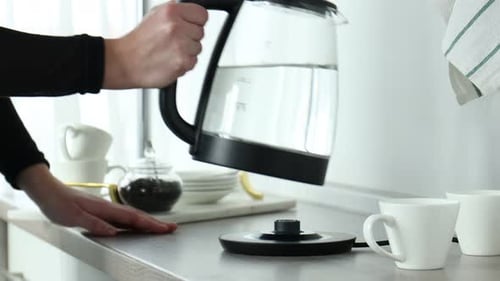 Filling Kettle with Water in Modern Kitchen Setting