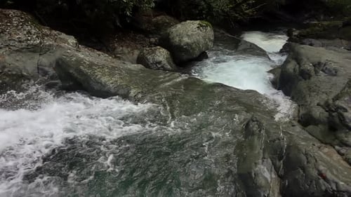 Waterfall Cascade Falling Through Stones and Rocks in the Woodland is Filmed From Above