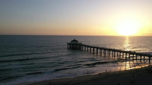 Warm Sunset Sky Illuminated Through Pacific Ocean In Manhattan Beach Pier, California USA. Wide Shot