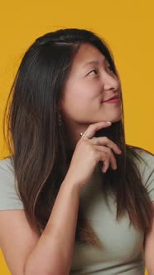 Young woman doubt and thinking with confusion isolated over yellow background in studio
