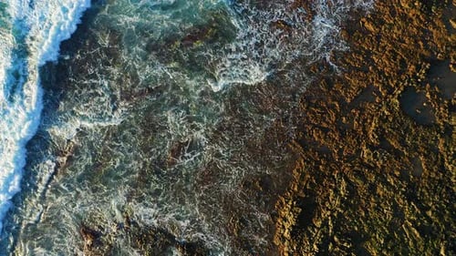 Soothing View of Ocean Waters Washing Volcanic Rocky Rough Beach
