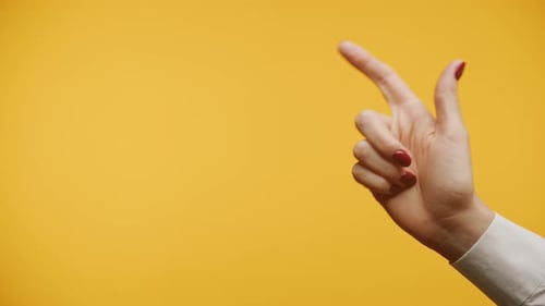 Handgeste, die auf gelbem Hintergrund zeigt