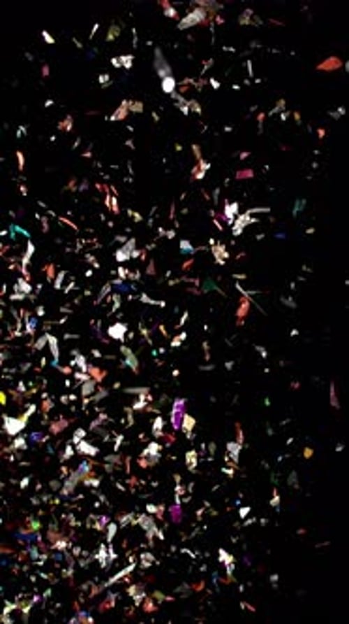 Iridescent Confetti Falling on Black Background