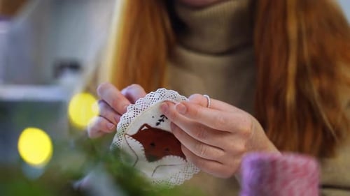 Woman Hand-Sewing Christmas Ornament at Home