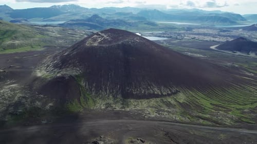 An aerial view of a large volcanic crater nestled within the mountains of Iceland. The crater sits i
