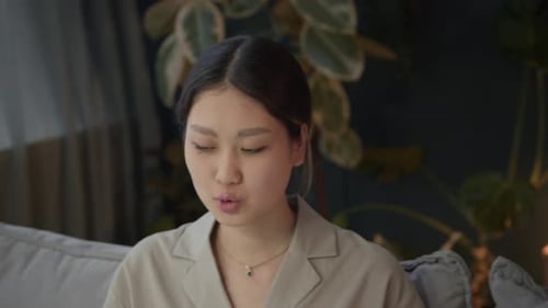 Woman Sitting on Couch while Her Boyfriend Talking on Smartphone at Home