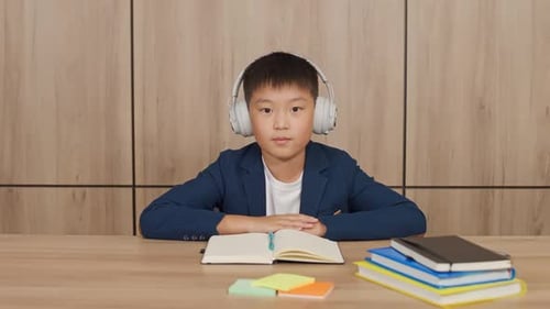 Boy With Headphones Studying at Desk
