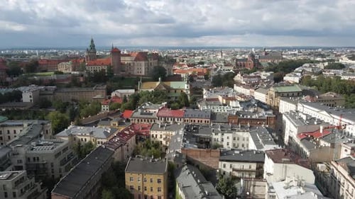 Wide aerial shot moving across the historic Krakow city in Poland on an overcast day
