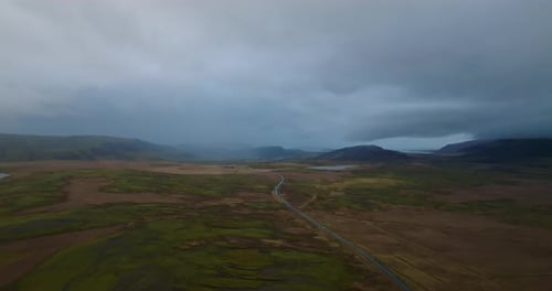 aerial view on icelandic road in rain woth mountains on background