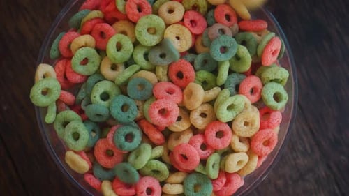 Colorful Corn Rings Falling Into a Bowl Top View Close Up