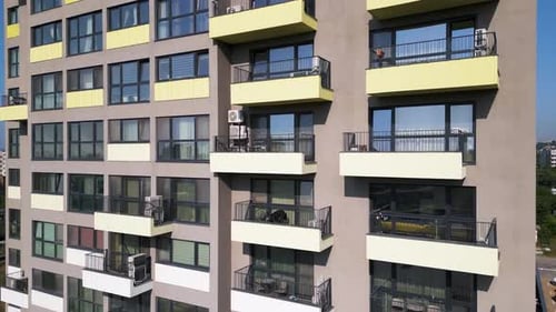 Modern Apartment Building with Colorful Balconies Shot By Drone Flying Closely Along the Facade