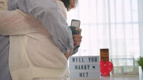 Close up of romantic man surprise girlfriend with a marriage proposal.