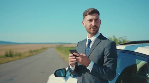 Happy Man in Business Suit Stand Near Car Use Smartphone on Road Conversation at Sunlight Transport