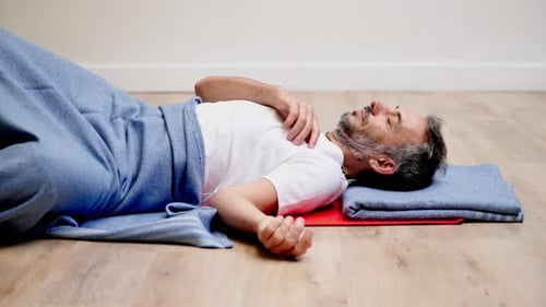Man practicing stretching forward in green garden with serene focus