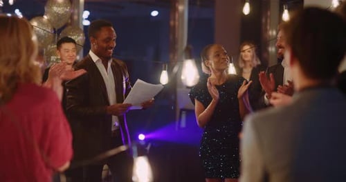 Homem afro-americano fazendo discurso em partido corporativo parabenizando seus colegas pelo melhor trabalho