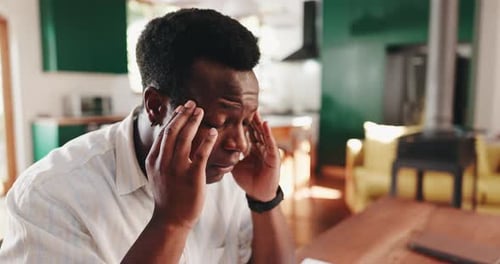 Stressed Man Massages Head and Temples Indoors