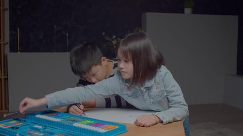 Engrossed Cute Asian School Age Sibling Drawing Picture with Felt Tip Pens