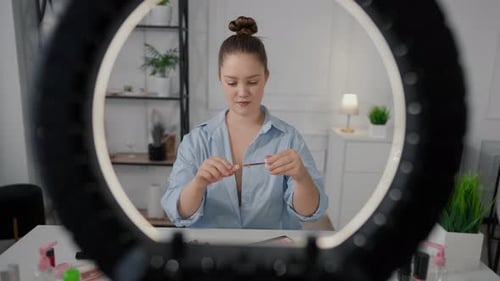 Joven bloguera que crea contenido para redes sociales filmando reseñas sobre maquillaje profesional cosmético