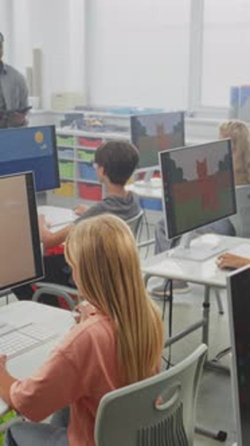 School Children Using Computers Creating Digital Illustrations Teacher Teaching Young Boys and Girls