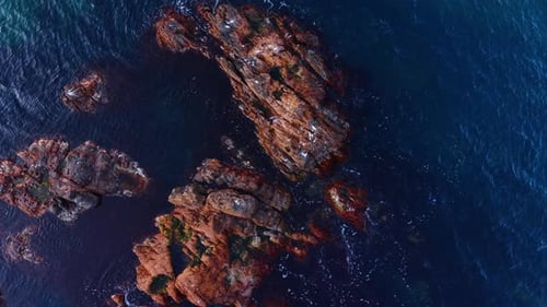 Dramatic Aerial View of Rocky Outcrops in Dark Ocean