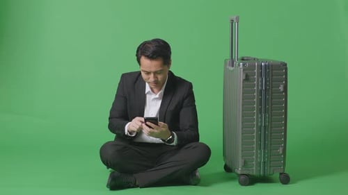 Businessman Traveler With Luggage Holding Using Smartphone While Sitting In The Green Screen
