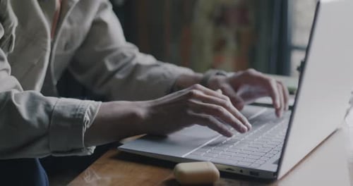 Typing on a Laptop Computer Indoors at Table