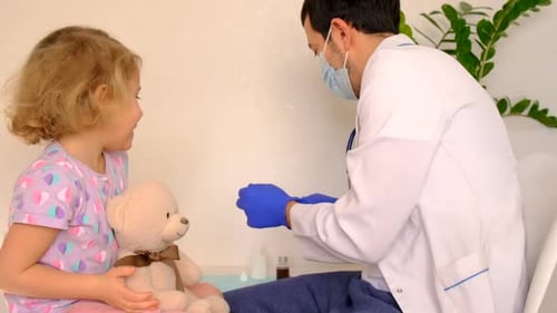 Doctor Vaccinating a Child in a Clinic Selective Focus