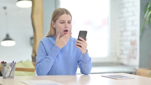 Woman Looks Shocked at Phone in Home