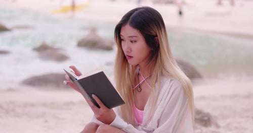 Cheerful Young Woman Reading Book on the Beach Near Sea at Phuket