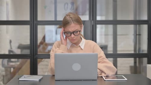 Woman Working at Desk Rubbing Temples