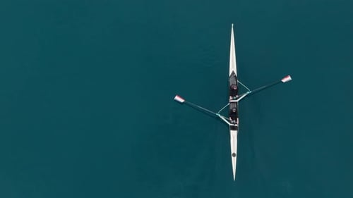 Zwei Athleten rudern im Ruderboot auf ruhigem Blauwasser Teamwork und Ausdauer im Leistungssport