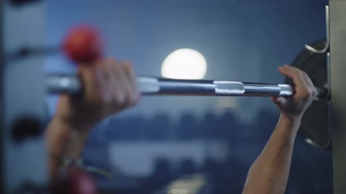 An Athlete Trains in the Gym Lifting a Barbell with His Hands