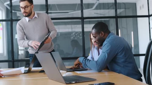 An angry boss scolds his subordinates. Professional workers are in the modern office together.