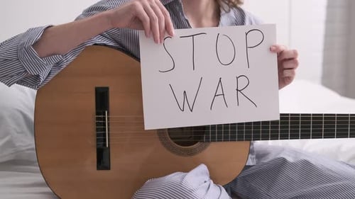 Woman Plays Guitar Symbol of Feast Pacific Sad Song Lettering on White Sheet No War Stop War