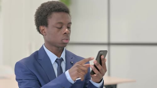 Man in Suit Annoyed by Something on Phone