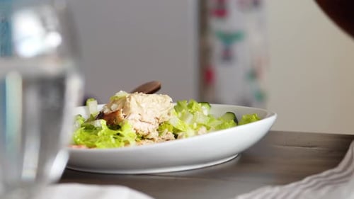 Man Sitting At Table In A Restaurant Eating Salad Of Vegetables and Chicken. - Closeup Shot