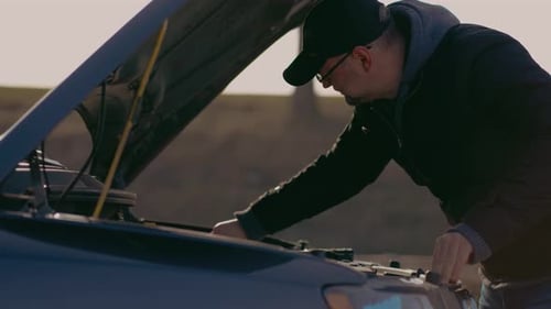 Adult Inspecting Under Car Hood during the Day