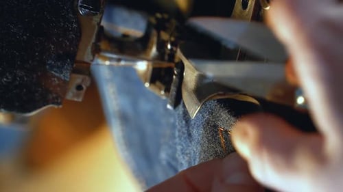 A Female Tailor Hemming Old Jeans with Vintage Machine
