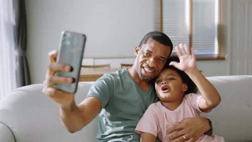 Father and Child Taking a Selfie on Couch