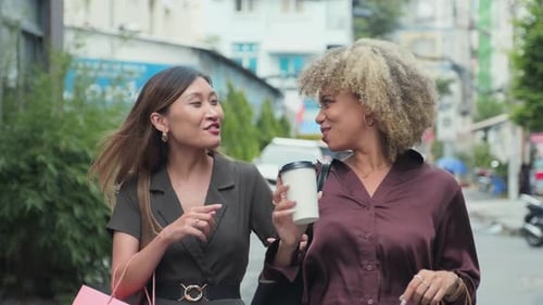Female Friends Walking with Shopping Bags and Chatting