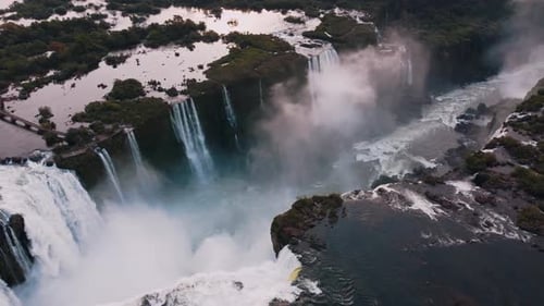 Aerial View of Majestic Waterfalls Surrounded by Lush Forest