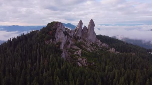 Aerial shot of mountains. Mountains, peaks, cliffs, rocks, ridges, landscape, green grass, sky, clou