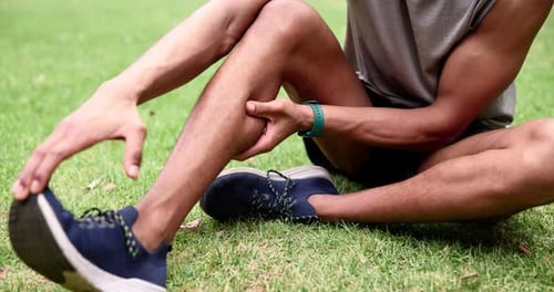 Runner, park and massage with leg, pain and cardio for exercise and health