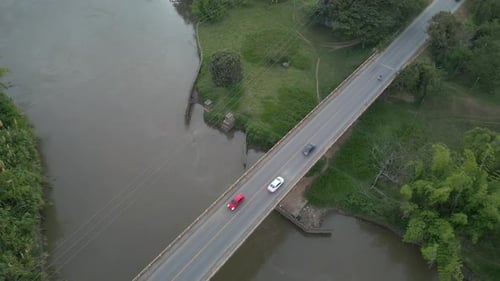 Aerial View of Cauca River Near Bridge with Passing Cars. Top View Ascending Shot. Valle del Cauca.