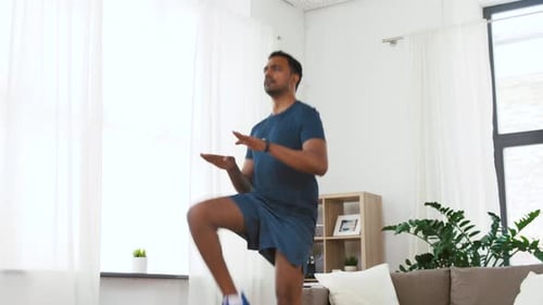Man doing high knees exercise in a living room