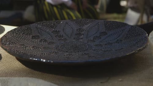 high quality colorful clay plates at artisan market with moving foliage shadows