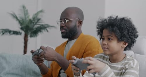 Man and Boy Playing Video Games at Home